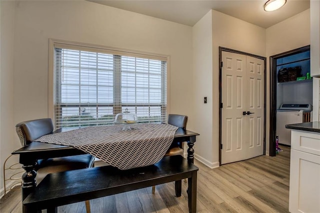 dining area featuring washer / clothes dryer and light wood-type flooring