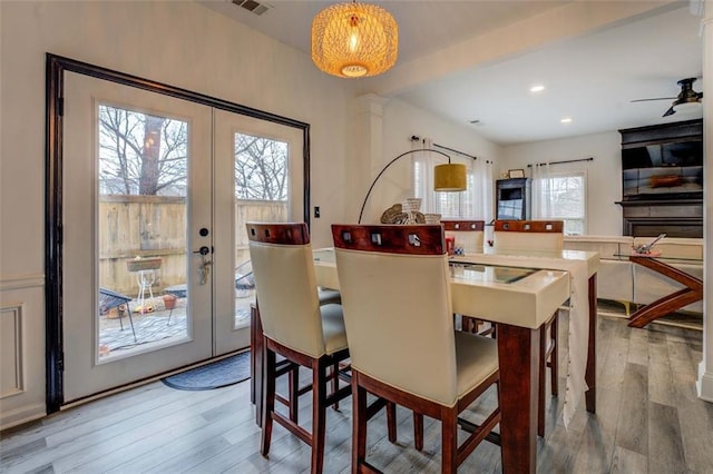 dining space featuring a wealth of natural light, light hardwood / wood-style floors, and french doors