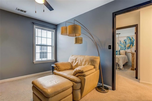 living area with ceiling fan and light colored carpet