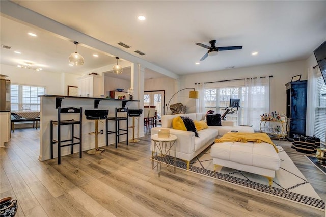 living room with ceiling fan, a healthy amount of sunlight, and light wood-type flooring