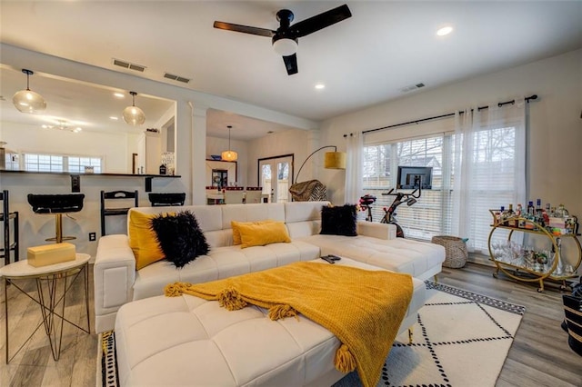 living room featuring wood-type flooring, french doors, and ceiling fan