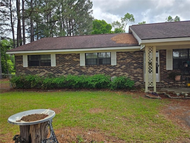 view of front of property featuring brick siding and roof with shingles