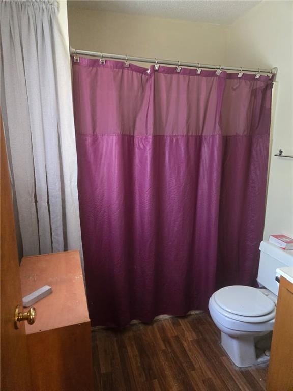 full bath featuring wood finished floors, toilet, vanity, a shower with shower curtain, and a textured ceiling