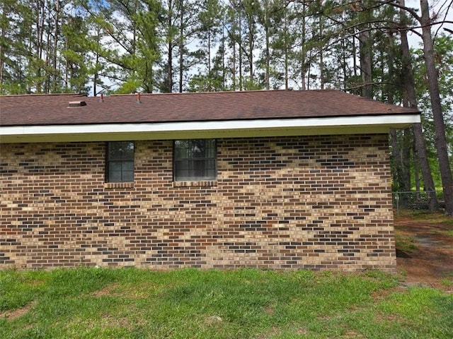 view of side of property featuring brick siding and fence