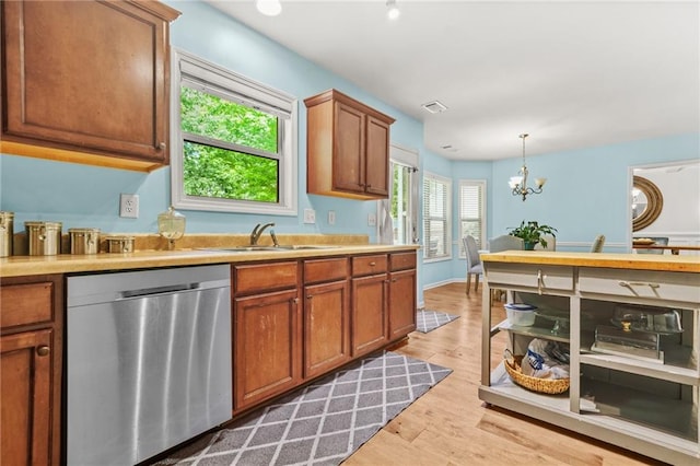 kitchen featuring dishwasher, a sink, light countertops, and brown cabinets