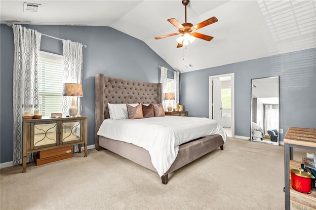 carpeted bedroom featuring vaulted ceiling, baseboards, ensuite bathroom, and a ceiling fan