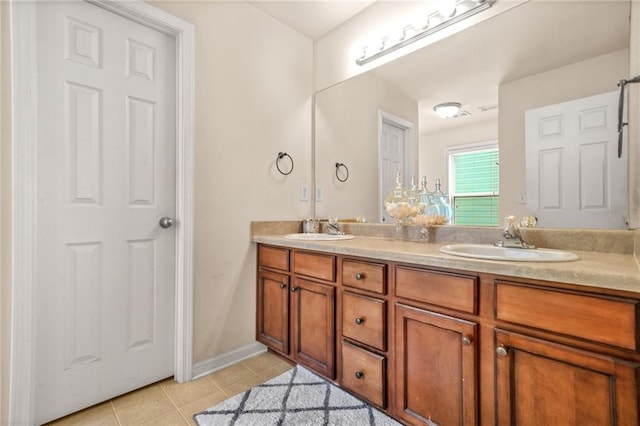 bathroom featuring tile patterned flooring, double vanity, and baseboards