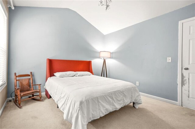 bedroom featuring carpet, vaulted ceiling, multiple windows, and baseboards