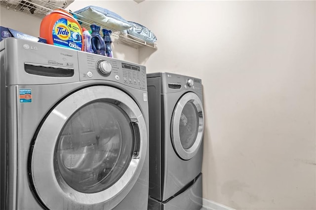 laundry area with washer and dryer and baseboards