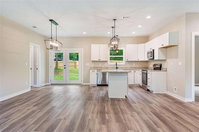 12 New St, Newnan, GA 30263 - kitchen featuring appliances with stainless steel finishes, baseboards, white cabinetry, a center island, and recessed lighting