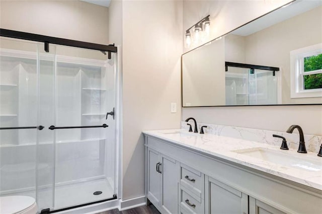 12 New St, Newnan, GA 30263 - bathroom featuring double vanity, a shower stall, toilet, and wood finished floors