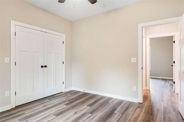 12 New St, Newnan, GA 30263 - unfurnished bedroom featuring wood finished floors, a closet, baseboards, and a ceiling fan