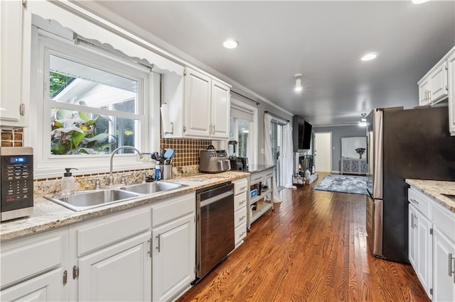 2900 Townley Cir, Atlanta, GA 30340 - kitchen with stainless steel appliances, a sink, white cabinets, backsplash, and dark wood finished floors