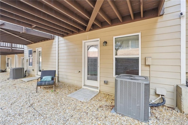 view of exterior entry featuring a patio and central AC