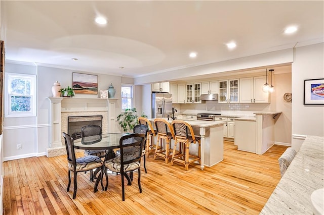 dining area featuring ornamental molding and light wood-type flooring