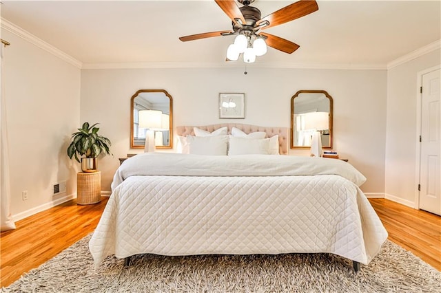 bedroom featuring hardwood / wood-style floors, ornamental molding, and ceiling fan