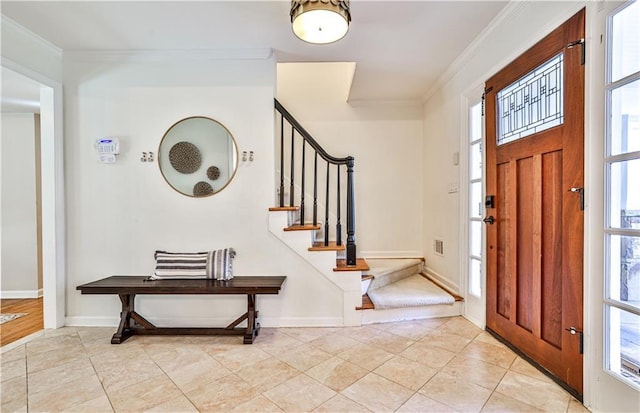 foyer with crown molding and light tile patterned floors