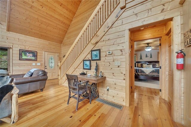 office area featuring wood walls, wood ceiling, light hardwood / wood-style floors, ceiling fan, and high vaulted ceiling