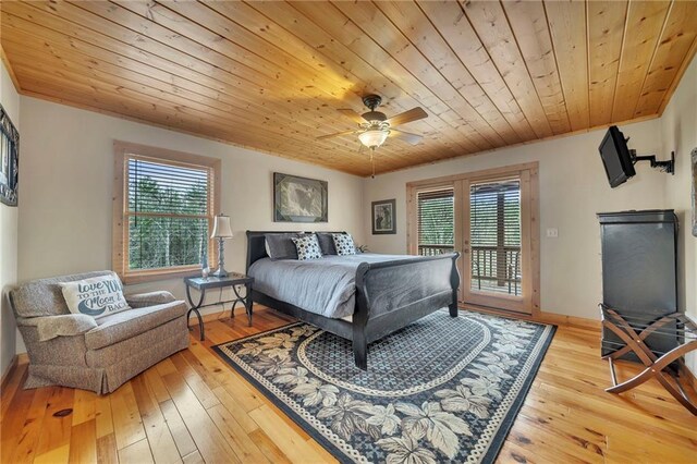 bedroom featuring access to outside, multiple windows, hardwood / wood-style floors, and ceiling fan