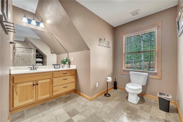 bathroom with vanity, toilet, walk in shower, and lofted ceiling