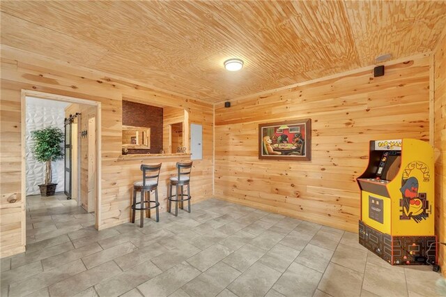 interior space with tile patterned flooring, wooden ceiling, and wood walls