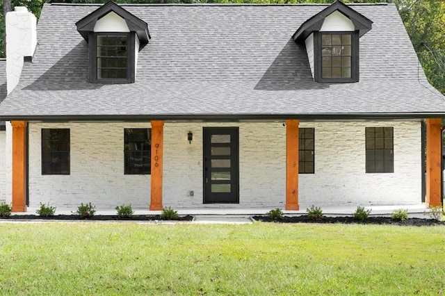 view of front facade with a porch, a front yard, and roof with shingles