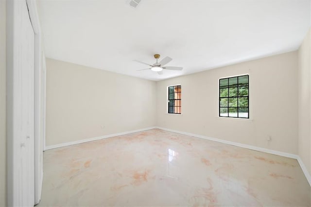 spare room with ceiling fan and baseboards