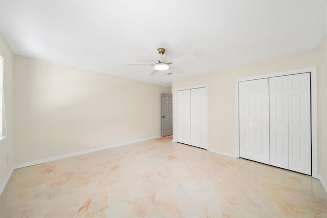 unfurnished bedroom featuring two closets, a ceiling fan, and baseboards