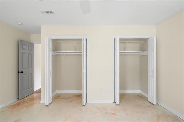 unfurnished bedroom featuring a ceiling fan, visible vents, baseboards, and two closets