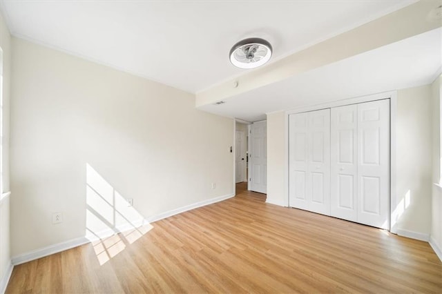 unfurnished bedroom featuring baseboards, a closet, and light wood-style floors