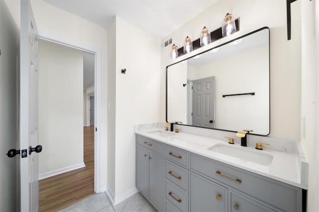 bathroom with visible vents, a sink, baseboards, and double vanity