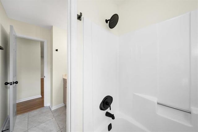 full bathroom with  shower combination, tile patterned floors, vanity, and baseboards