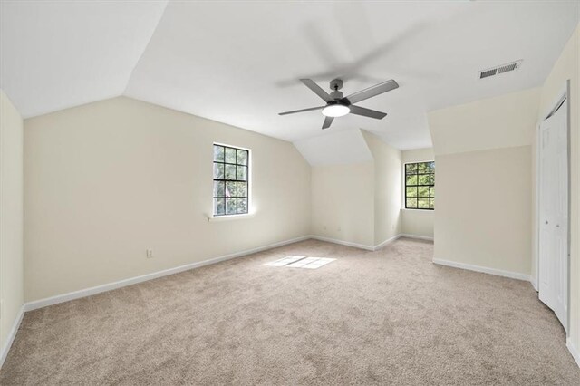 bonus room with plenty of natural light, visible vents, and light colored carpet