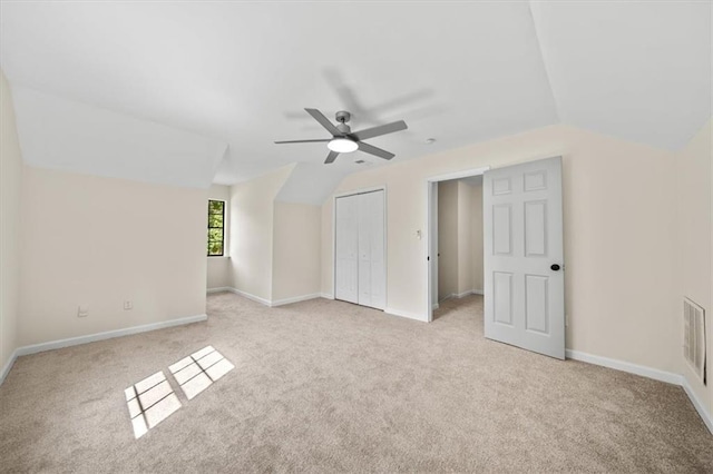 bonus room with light colored carpet, visible vents, vaulted ceiling, and baseboards