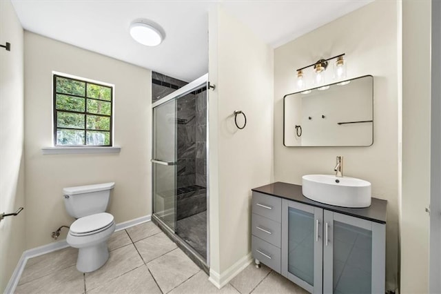 full bathroom with toilet, a stall shower, vanity, baseboards, and tile patterned floors