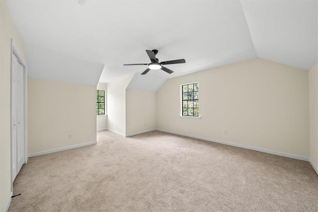 bonus room featuring ceiling fan, baseboards, vaulted ceiling, and light colored carpet