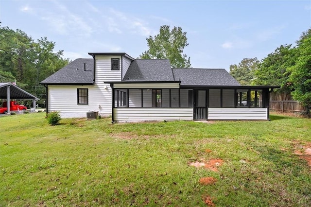 back of house featuring a sunroom, roof with shingles, fence, cooling unit, and a yard