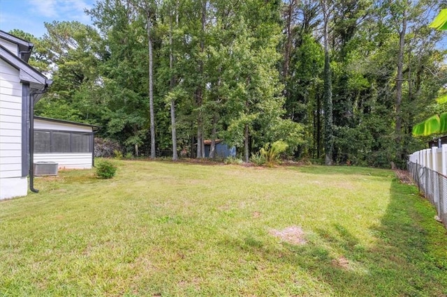 view of yard featuring central AC unit, fence, and a sunroom