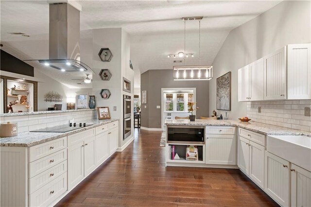 kitchen featuring dark wood-style floors, island exhaust hood, lofted ceiling, a peninsula, and black electric cooktop