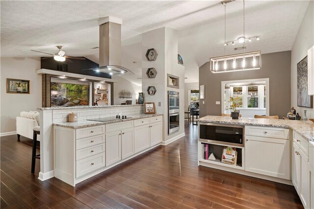 kitchen featuring island range hood, dark wood-style floors, a peninsula, built in microwave, and black electric cooktop