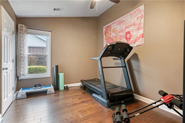 workout area featuring visible vents, ceiling fan, baseboards, and wood finished floors