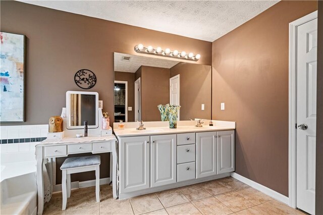 full bath featuring a textured ceiling, a garden tub, tile patterned flooring, a sink, and double vanity