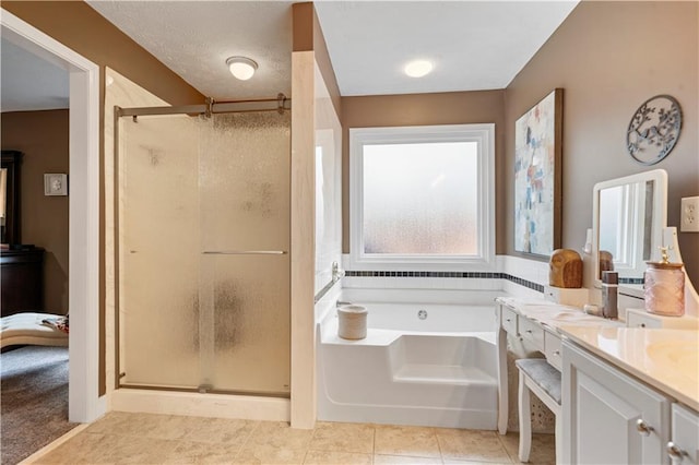 bathroom with a stall shower, a garden tub, vanity, and tile patterned floors