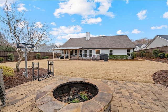 back of property featuring an outdoor fire pit, a fenced backyard, a chimney, and a patio