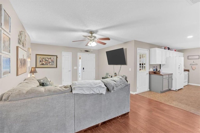 living room with dark hardwood / wood-style floors, ceiling fan, and a textured ceiling