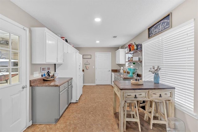 kitchen featuring sink, white cabinets, a healthy amount of sunlight, and white refrigerator