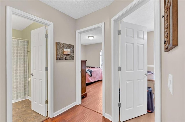 corridor featuring hardwood / wood-style flooring and a textured ceiling