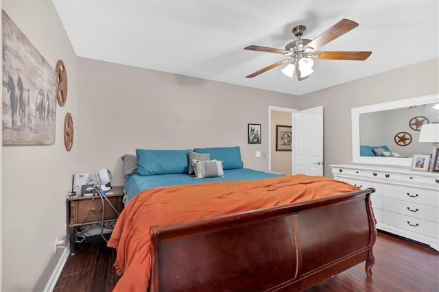 bedroom with a textured ceiling, ceiling fan, and dark hardwood / wood-style floors