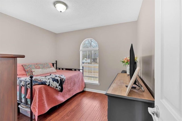 bedroom featuring dark wood-type flooring and a textured ceiling