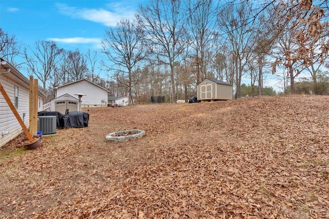 view of yard with central air condition unit and a storage unit